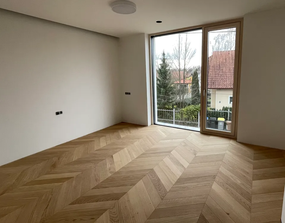 Parket Chevron, natur, lakiran, svijetli hrast u praznom prostoru s velikim prozorom