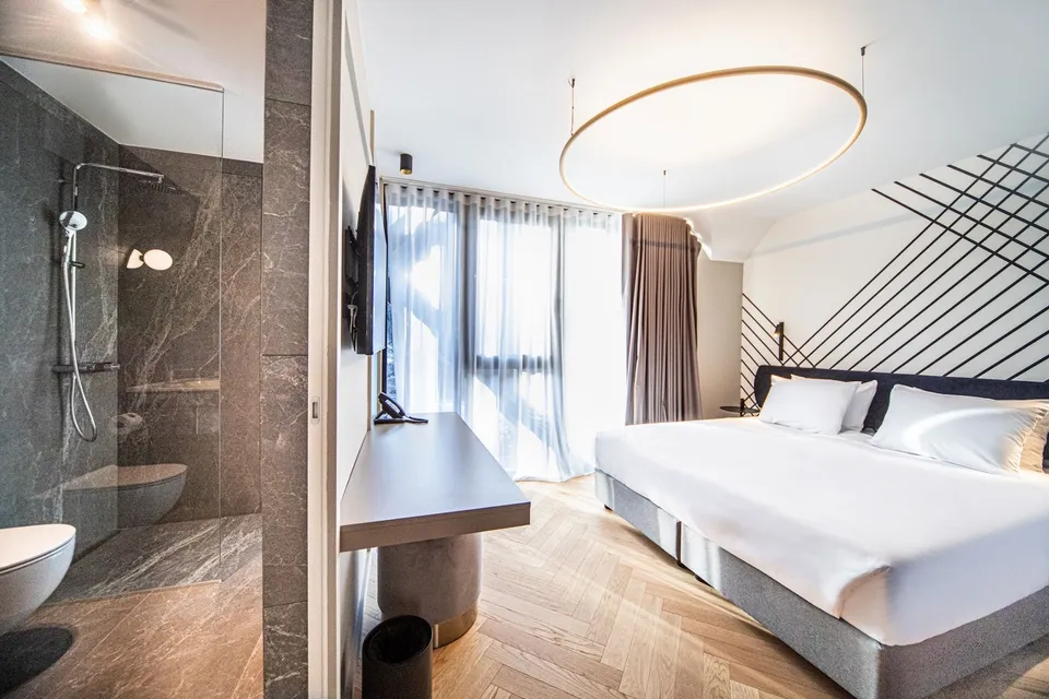 Parket po meri v vzorcu ribja kost v hotelski sobi s kopalnico